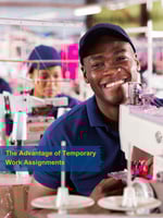 Smiling man sitting behind an industrial sewing machine.