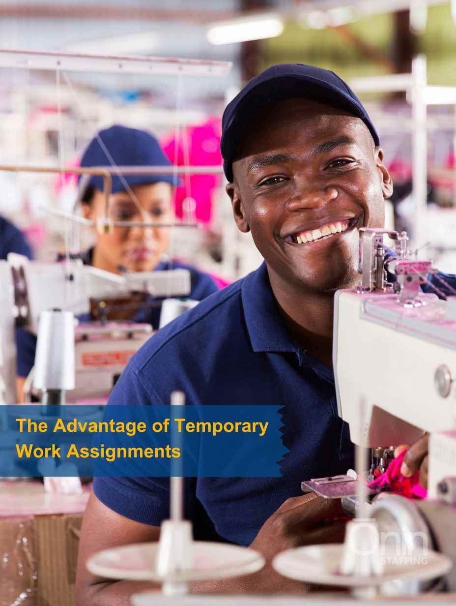 Smiling man sitting behind an industrial sewing machine.